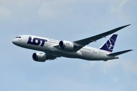 Samolot LOT Polish Airlines z numerem lotu SP-LRF wznosi się na błękitne niebo.