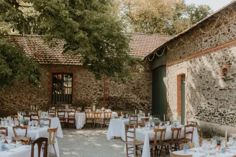 Tables dressées pour un mariage thème champêtre, sous les arbres et à l'ombre des vieilles pierres.