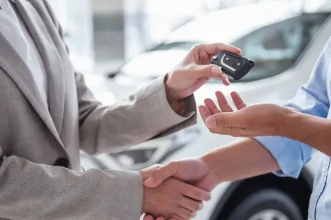 Przekazanie kluczyków do auta to ważny etap, jak przygotować auto do sprzedaży. Uściski dłoni i nowy właściciel.