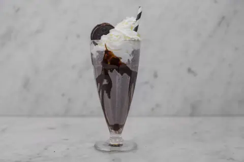 En krämig oreo milkshake med vispgrädde, chokladsås och en hel oreokaka. Perfekt för en fika!