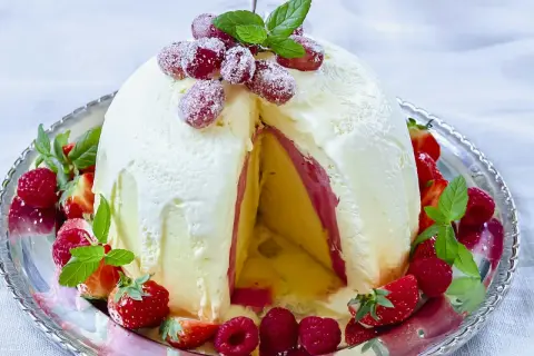 En magnifik elle nyårsdessert, en kupol av glass med lager av frukt och bär, dekorerad med färska jordgubbar och hallon.