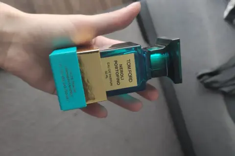 Dłoń trzyma buteleczkę perfum Tom Ford Neroli Portofino.
