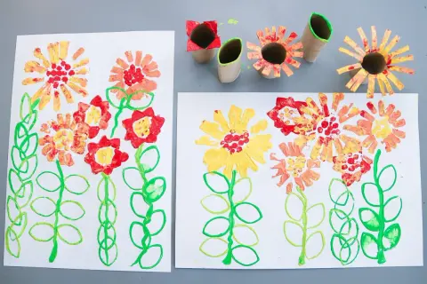 Barnens pyssel blommor med färgglada stämplar av toarullar.