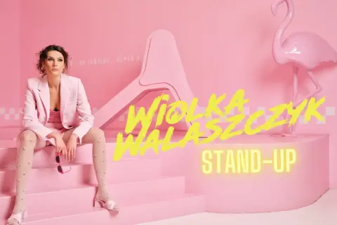 Wiola Walasczyk gotowa na stand-up. Siedzi na różowych schodach obok flaminga.