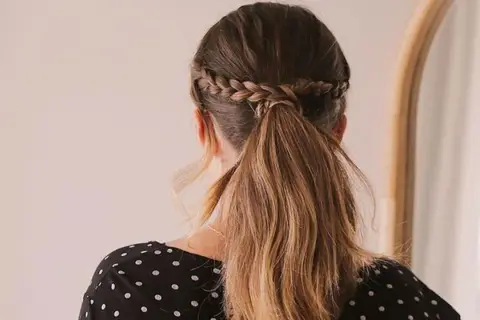 Peinados romería: coleta baja con trenza diadema, ideal para un día de campo o celebración.