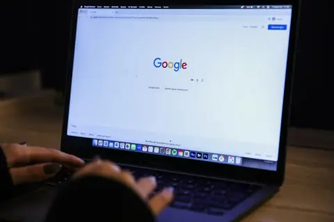 Osoba wpisuje w wyszukiwarkę Google frazę "jak zablokować ai w google", szukając informacji o ograniczeniu sztucznej inteligencji.