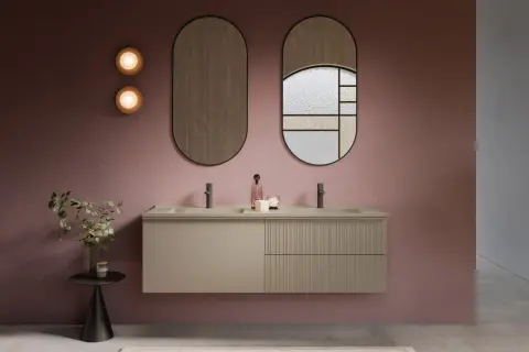Nowoczesna łazienka z podwójną umywalką nablatową. Elegancka szafka łazienkowa w kolorze beżowym, wisząca na ścianie. Dwa owalne lustra nad umywalką.