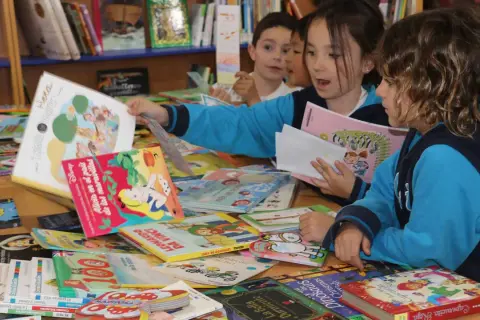 Niños exploran libros, una forma divertida de mejorar la comprensión lectora.