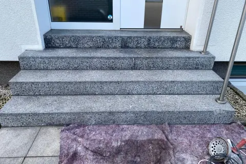 Schritt für Schritt wird die Marmortreppe gereinigt. Ein Schutzvlies liegt bereit, Werkzeug für die Reinigung ist zu sehen.
