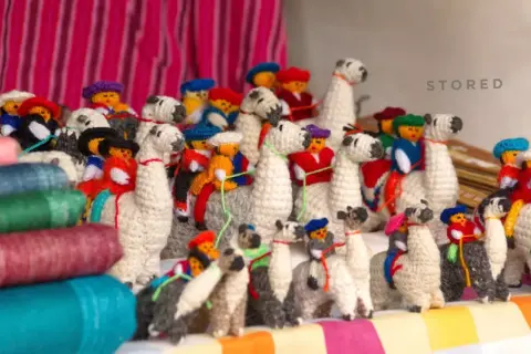 A collection of charming, handmade llama stuffed animals, showcasing creative stuffed animal storage ideas.