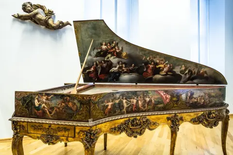 Ein prachtvolles Cembalo, verziert mit barocken Malereien, wie sie Johann Sebastian Bach liebte. Ein geflügelter Putto schwebt darüber.