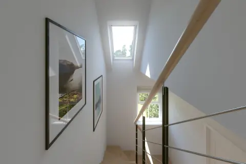 Escalera moderna con barandilla de madera y metal. Dos cuadros decoran la pared. Ventanas en pasillos interiores inundan de luz natural el espacio.