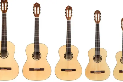 Rząd gitar klasycznych i akustycznych. Zobacz, czym się różni gitara klasyczna od akustycznej, porównując ich rozmiary i detale.
