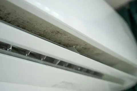 Brudny panel klimatyzacji domowej, widoczny nalot pleśni. Czas na czyszczenie klimatyzacji domowej, by zapewnić czyste powietrze.