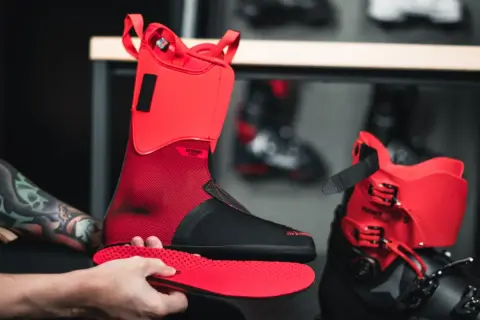 Czerwone buty narciarskie Atomic Hawk Prime, z czarną wkładką, gotowe do sezonu. Zastanawiasz się, ile ważą buty narciarskie?