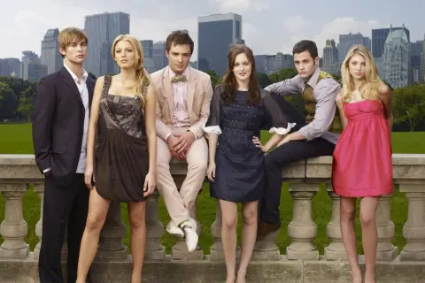 Die Hauptbesetzung von Gossip Girl posiert vor der Skyline von New York.
