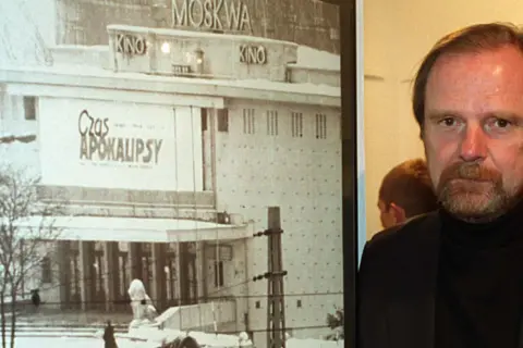 Chris Niedenthal obok plakatu "Czas Apokalipsy" z kinem Moskwa w tle.