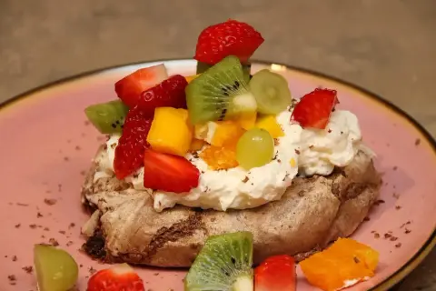 En chokladpavlova med vispgrädde och färsk frukt som jordgubbar, kiwi och mango. En härlig dessert!