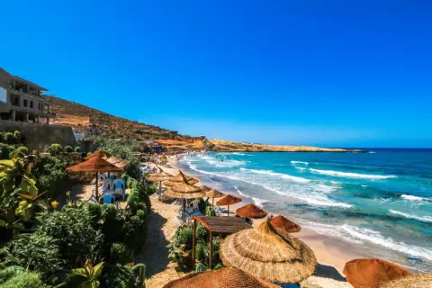 Słoneczne plaże Tunezji, idealne na wakacje. Turkusowe morze, złoty piasek i palmy tworzą rajski krajobraz.