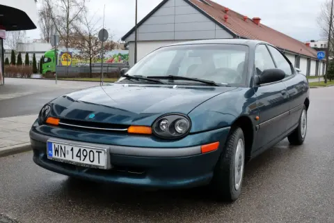Zielony Dodge Neon z tablicą rejestracyjną WN 1490T stoi na mokrej drodze.