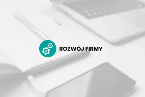 Na biurku leży notatnik z długopisem, obok laptop i telefon. Ikona z trybikami symbolizuje rozwój firmy, czyli jej promesa.