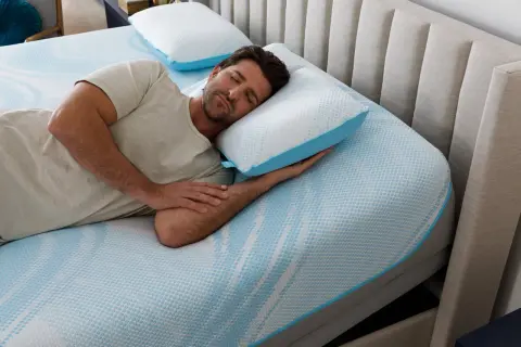 Man sleeping peacefully on a Tempur-Pedic pillow, enjoying the comfort and subtle, fresh tempurpedic pillow smell.