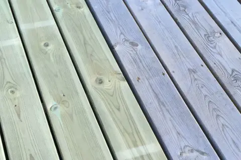 Trallen är delvis målad i en ljusgrå nyans, vilket ger en fin kontrast mot den obehandlade delen. Snart är hela trallen klar att njuta av.