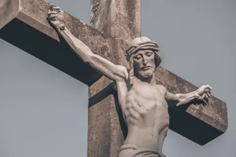 Kamienna rzeźba Jezusa na krzyżu, z wyrazem cierpienia na twarzy. Wzrok skierowany w dół, jakby w geście modlitwy do Jezusa o pomoc w trudnych chwilach.
