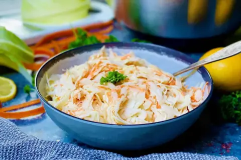 Frischer Krautsalat mit Karotten, perfekt für jedes coleslaw rezept. Ein Löffel liegt bereit.