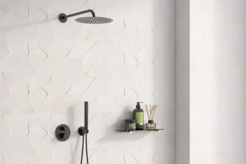 Ducha moderna con azulejo rectificado de diseño geométrico en blanco. Incluye rociador, grifería negra y estante con productos de baño.
