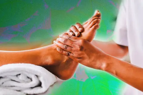 Mains expertes prodiguant un massage pied relaxant, avec une serviette blanche enroulée à proximité.