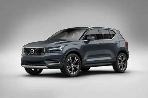 Elegancki, ciemnoszary Volvo XC40 prezentuje się na tle jasnej ściany, gotowy na miejskie wyzwania.