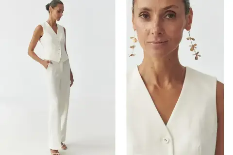 Elegancka kobieta w białej kamizelce i spodniach pokazuje, jak nosić kamizelkę na co dzień i od święta.