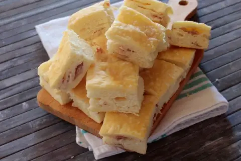 Sfiziose fette di gnocco fritto al forno, con un ripieno di prosciutto, pronte per essere gustate.
