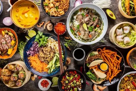 Vielfalt an asiatischem Essen: Pho, Frühlingsrollen, gedämpfte Teigtaschen, gebratene Nudeln und mehr.