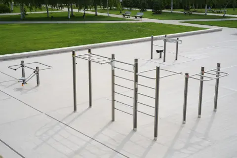 Un parc de street workout avec barres de traction, échelles et agrès pour un entraînement en plein air.