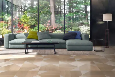 Soggiorno moderno con divano verde e pavimenti innovativi per interni con motivo geometrico in legno.