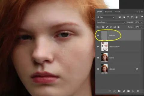 Primo piano di un volto femminile con capelli rossi. Pannello Livelli di Photoshop aperto, evidenziato il livello "texture" per la separazione delle frequenze.