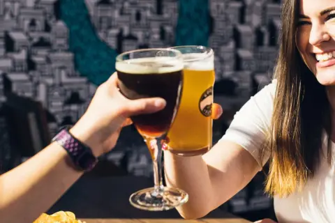 Dwie kobiety wznoszą toast piwem. Jedno ciemne, drugie jasne. Czy to kwarta piwa?