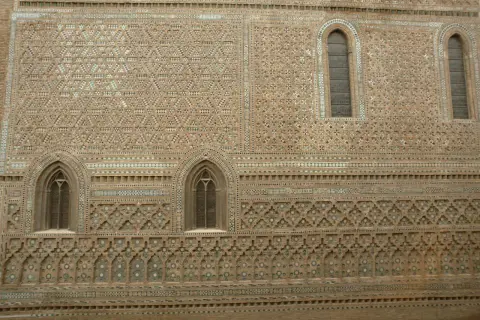 Detalle de la fachada de la parroquieta de la Seo, con intrincados mosaicos de ladrillo y azulejos formando patrones geométricos y florales.