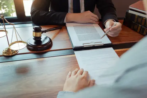 Prawnik wskazuje na dokument, omawiając sytuacje, kiedy odrzucenie spadku jest nieskuteczne. Waga sprawiedliwości i młotek sędziowski symbolizują prawo.