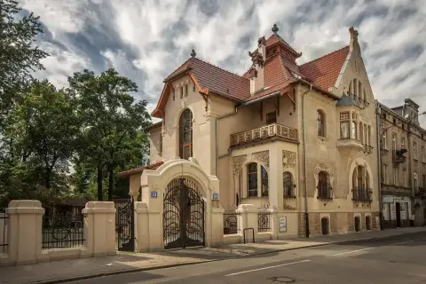 Elegancka willa w stylu secesja Młoda Polska, z bogatymi zdobieniami i kutą bramą.