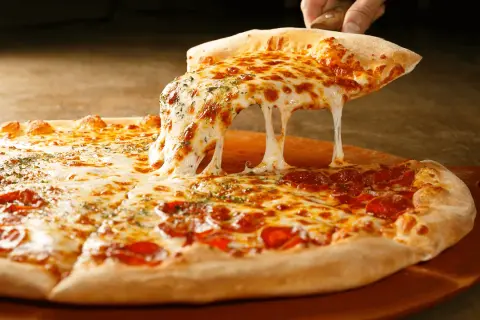 Pyszne, ciągnące się serowe ciasto na pizzę, idealne do domowego wypieku. Jak zrobić ciasto na pizzę?