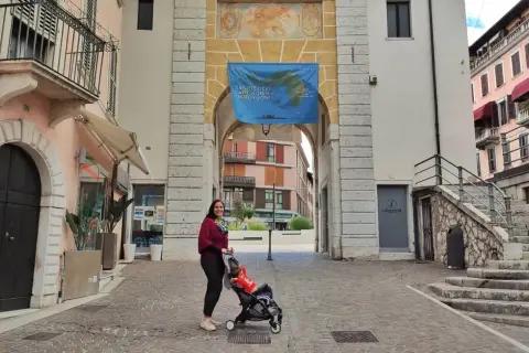 Donna con passeggino sotto un arco a Salò, tra le tante cose da fare.