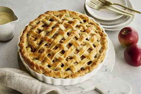 Goldbrauner Apfelkuchen mit Gittermuster, perfekt für Ihr nächstes apple pie rezept. Dazu passt Vanillesauce.