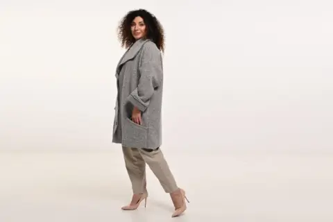 Elegancka, szara kurtka damska wiosenna, duże rozmiary. Modelka prezentuje wygodny krój i stylowe detale.