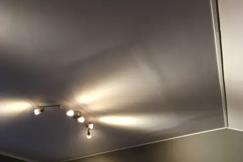 Taket är gipsat och skarvarna är spacklade. En taklampa med flera spotlights lyser upp rummet.