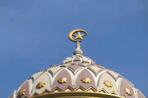 Złoty półksiężyc z gwiazdą na szczycie kopuły meczetu, symbol wiary. Bismillah.