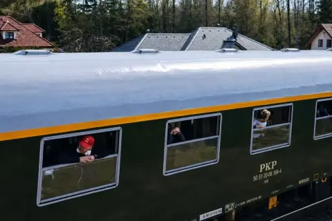 Pociąg retro PKP z pasażerami wyglądającymi przez okna. Sprawdzam pociąg retro rozkład jazdy.