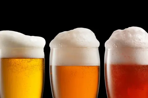Tre bicchieri di birra con abbondante schiuma. La schiuma della birra fa male? Forse, ma è bellissima da vedere.